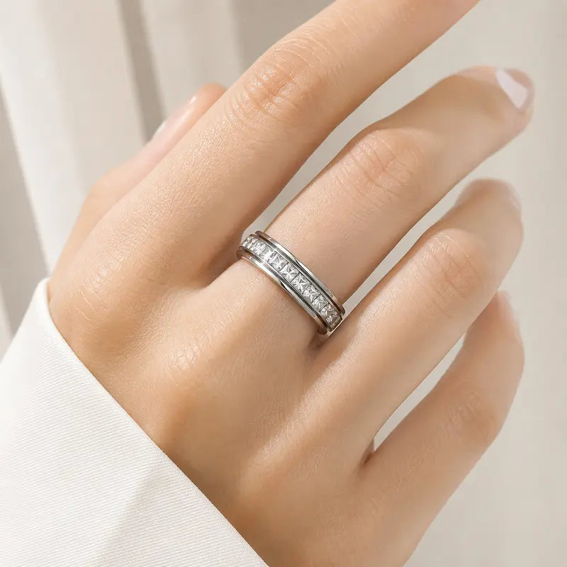 Silver crystal spinner ring worn on a hand